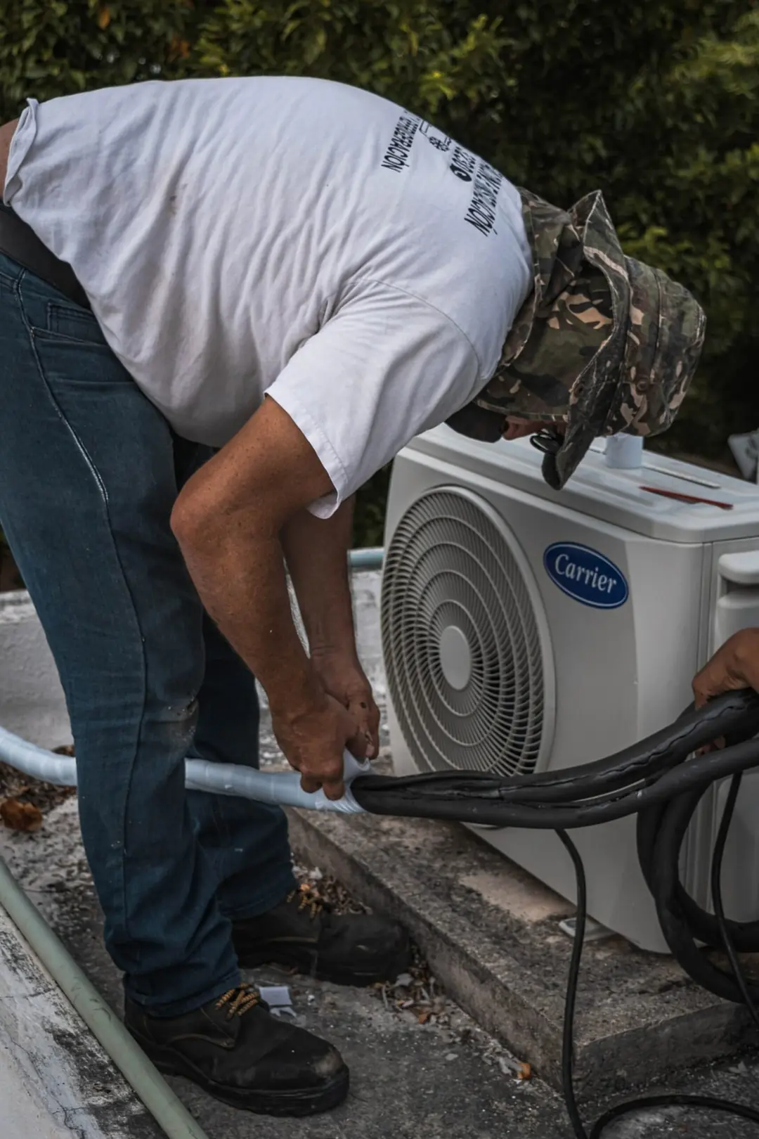 Engineer connecting refrigerant pipework to a new outdoor condenser